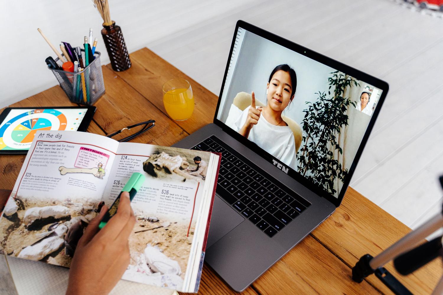 Sesión de enseñanza online a través de un portátil, ilustrando la venta de infoproductos y cursos digitales.