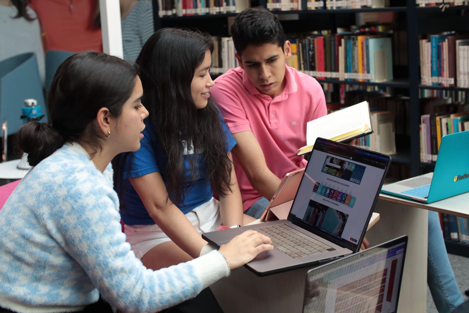 Estudiantes universitarios investigando y colaborando en una biblioteca, ideal para representar la elaboración de proyectos académicos y TFG.