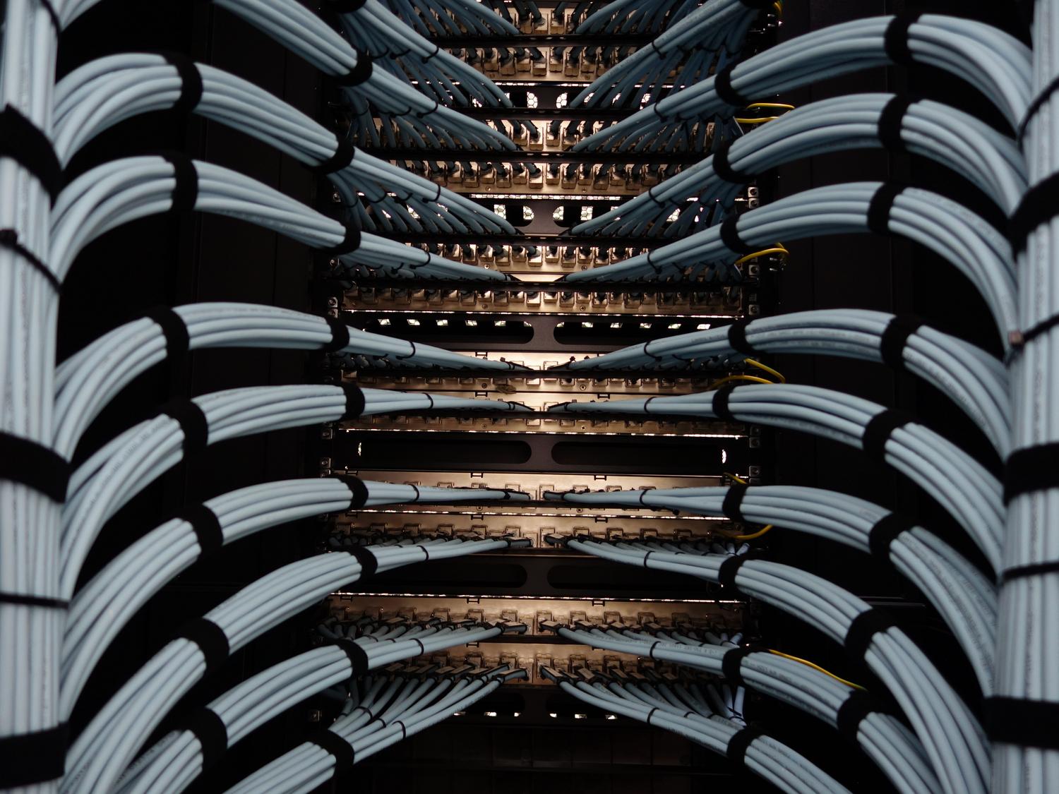 Highly organized and bundled network cables representing the strategy of consolidation and operational simplification.