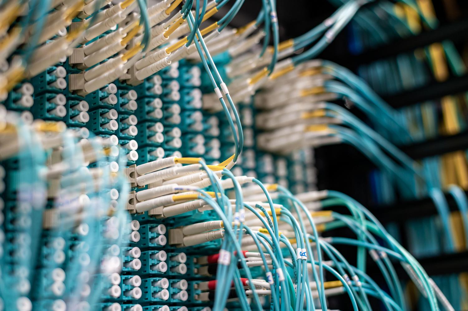 Tangled network cables in a data center representing the operational complexity and tool sprawl in cybersecurity.