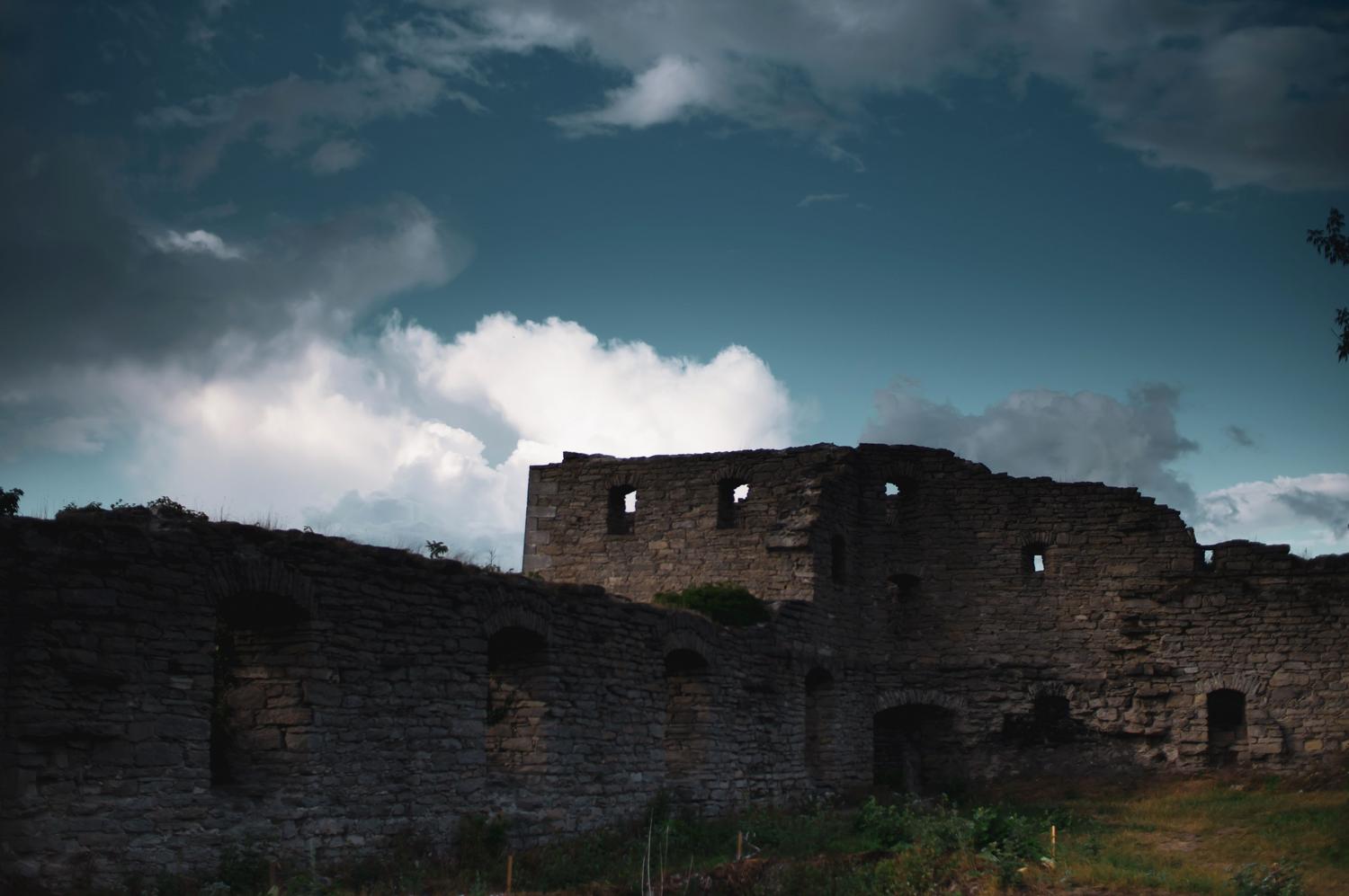 Ruinas de un castillo gótico bajo un cielo nublado y dramático, similar a las localizaciones del juego.