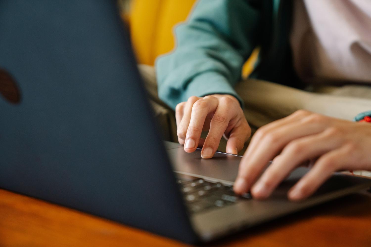 Persona realizando el trámite de solicitud de la etiqueta ambiental de forma online a través de un ordenador portátil en casa.