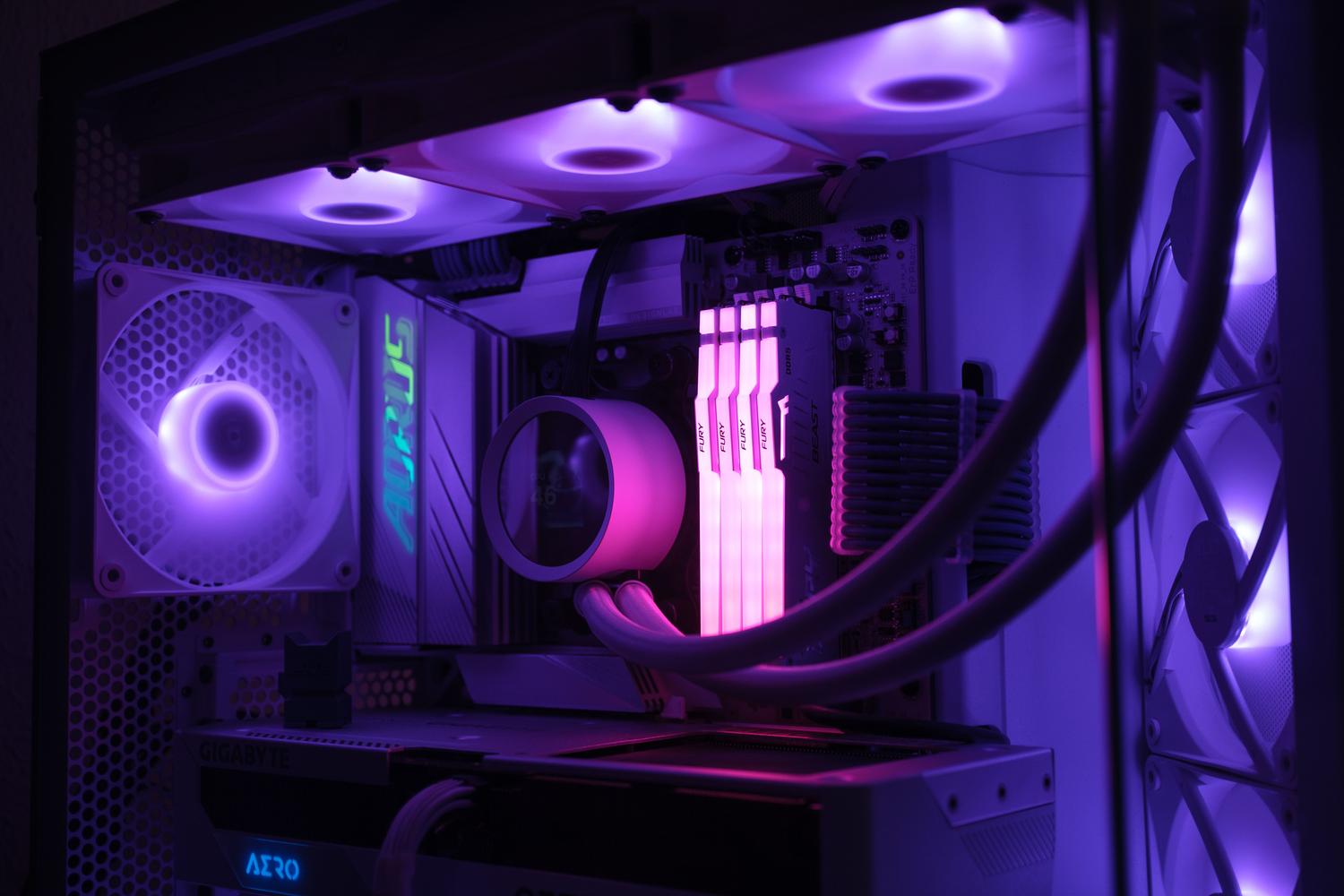 Interior de un PC gaming blanco con iluminación RGB en tonos púrpuras y magenta.