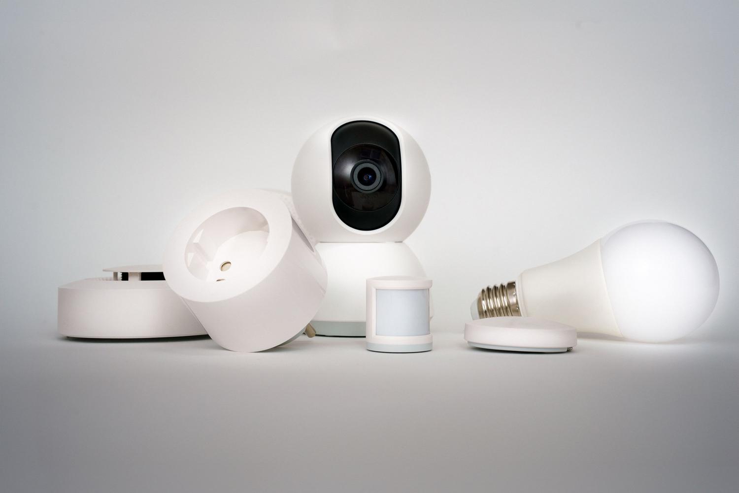 Dispositivos de hogar inteligente como sensores y bombillas LED en un entorno minimalista para la optimización energética.