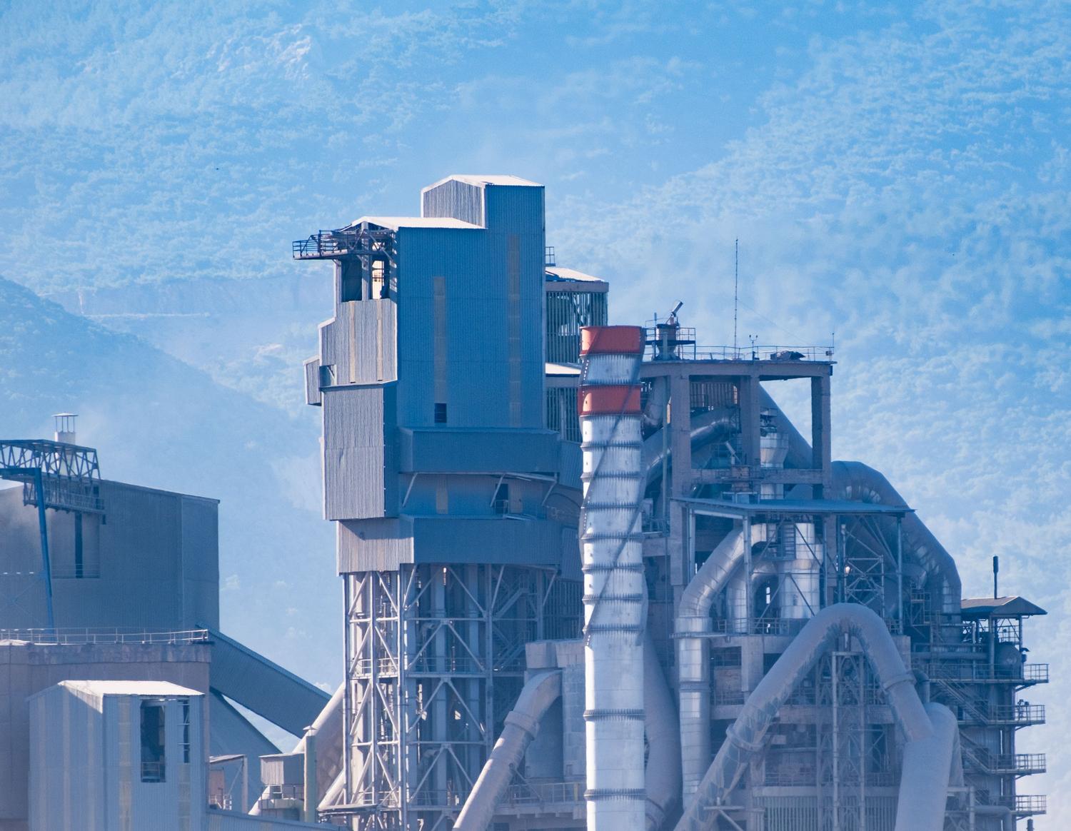 Instalación industrial moderna con montañas al fondo, representando la eficiencia energética en el sector industrial.