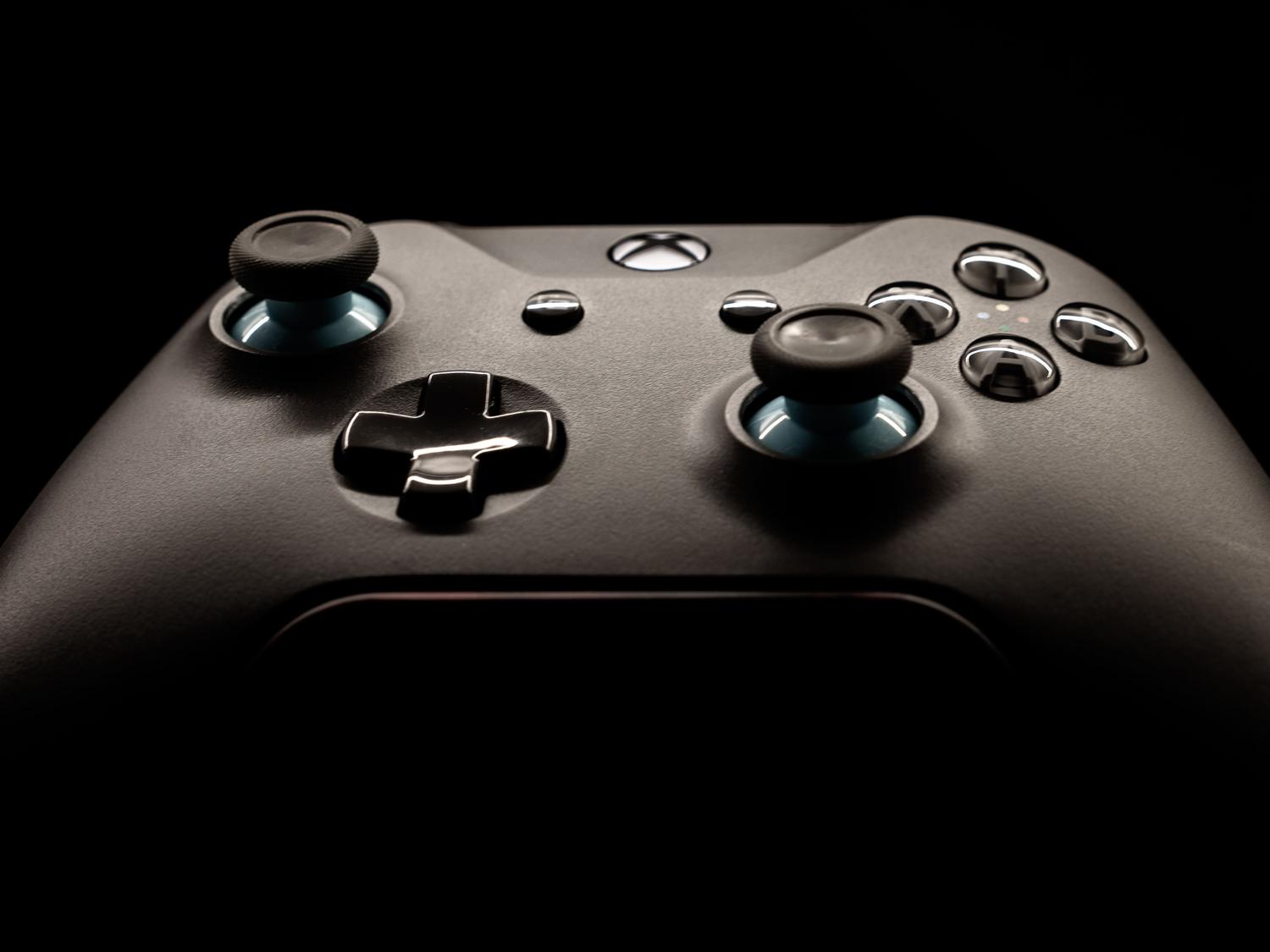 Primer plano detallado de un mando de Xbox resaltando su diseño ergonómico y botones translúcidos.