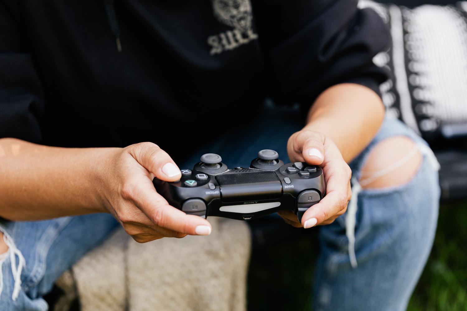 Manos sosteniendo un mando de videojuego, ilustrando la ergonomía y la interacción del jugador con el dispositivo.