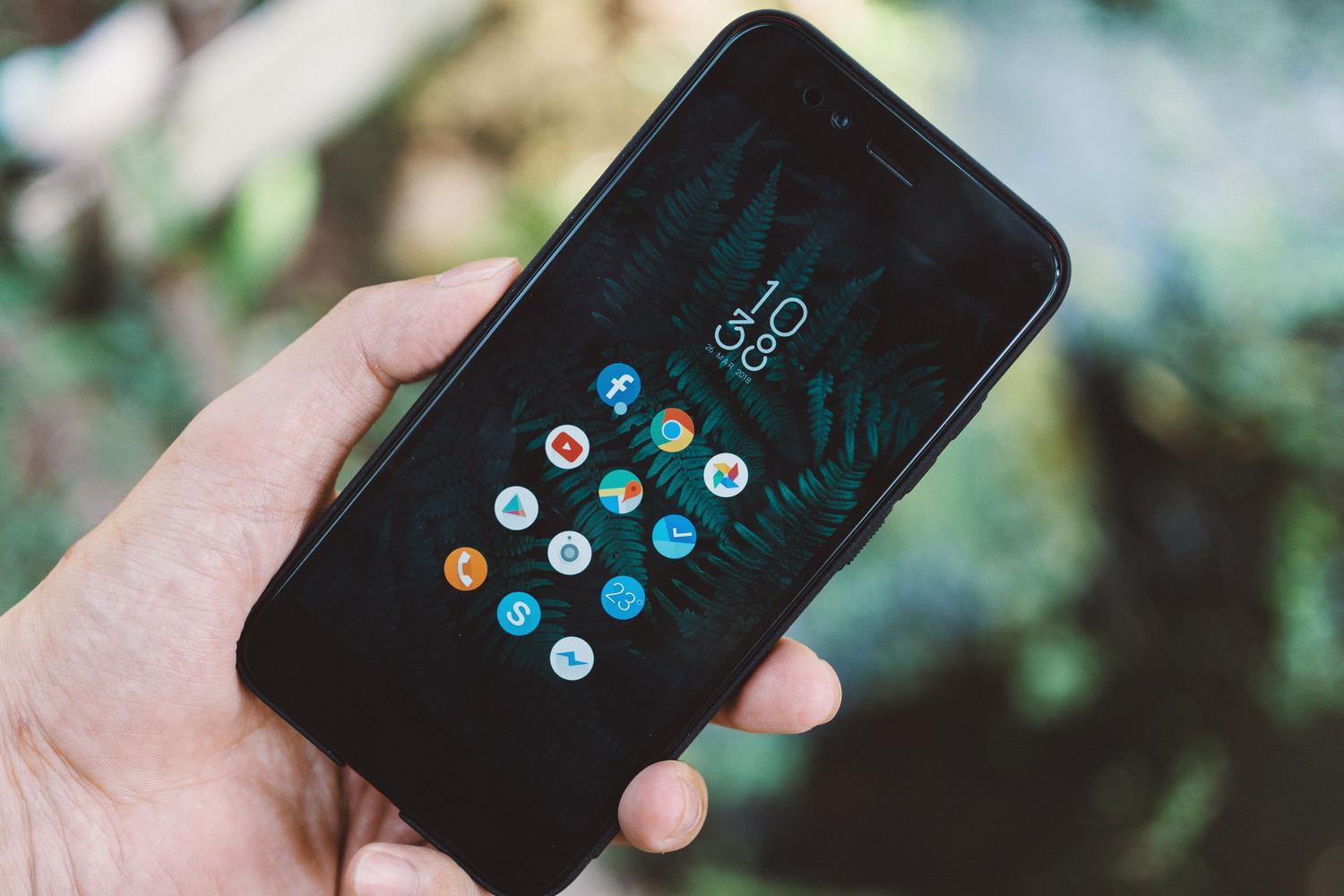 Persona sosteniendo un teléfono móvil inteligente para gestionar contenidos de redes sociales.