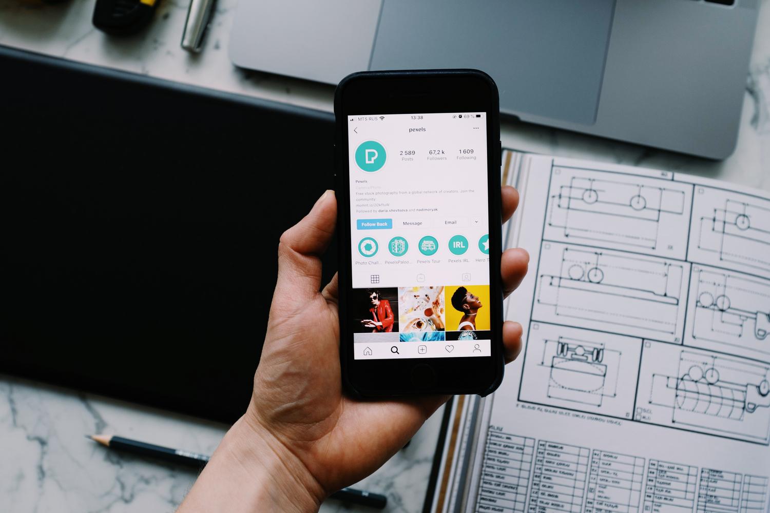 Primer plano de una mano sosteniendo un smartphone que muestra un perfil de redes sociales, ilustrando el concepto de identidad digital.