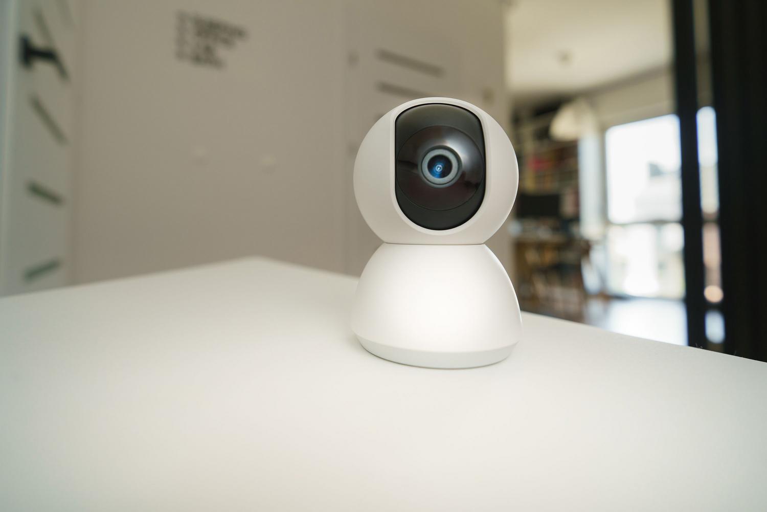 Cámara de vigilancia inteligente situada en un interior, representando los sistemas de seguridad conectados y el control remoto.