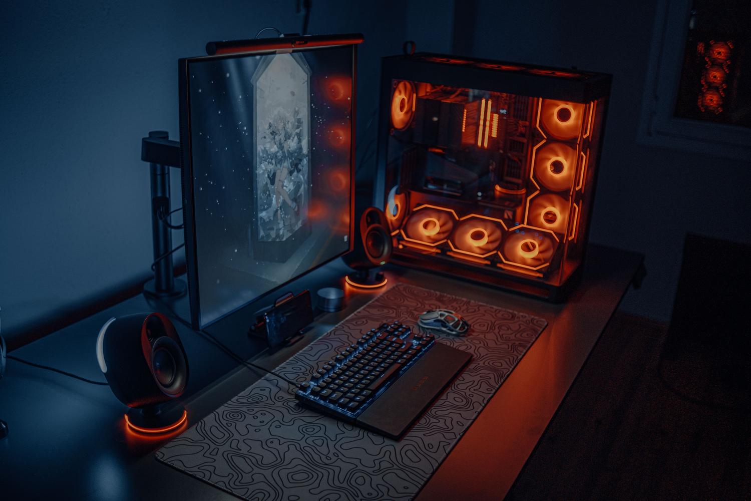 Configuración de PC gaming moderna con iluminación RGB naranja, ilustrando la potencia necesaria para gaming avanzado en Windows y Linux.