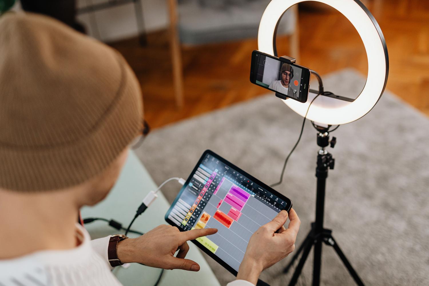 Persona editando audio y vídeo en una tablet, ideal para ilustrar la extracción de sonido de clips de redes sociales.