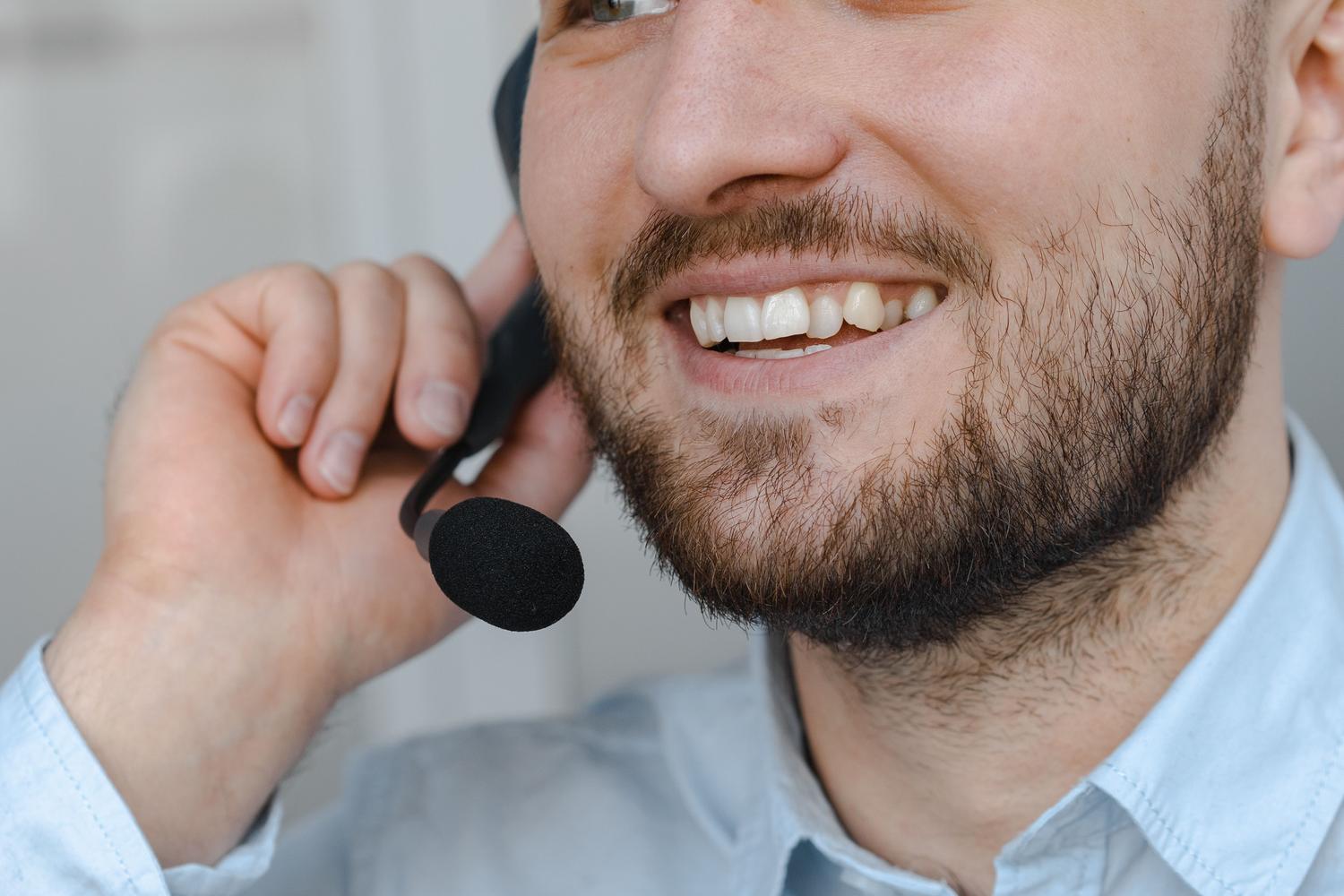 Agente de atención al cliente sonriendo con auriculares, representando un servicio posventa humano