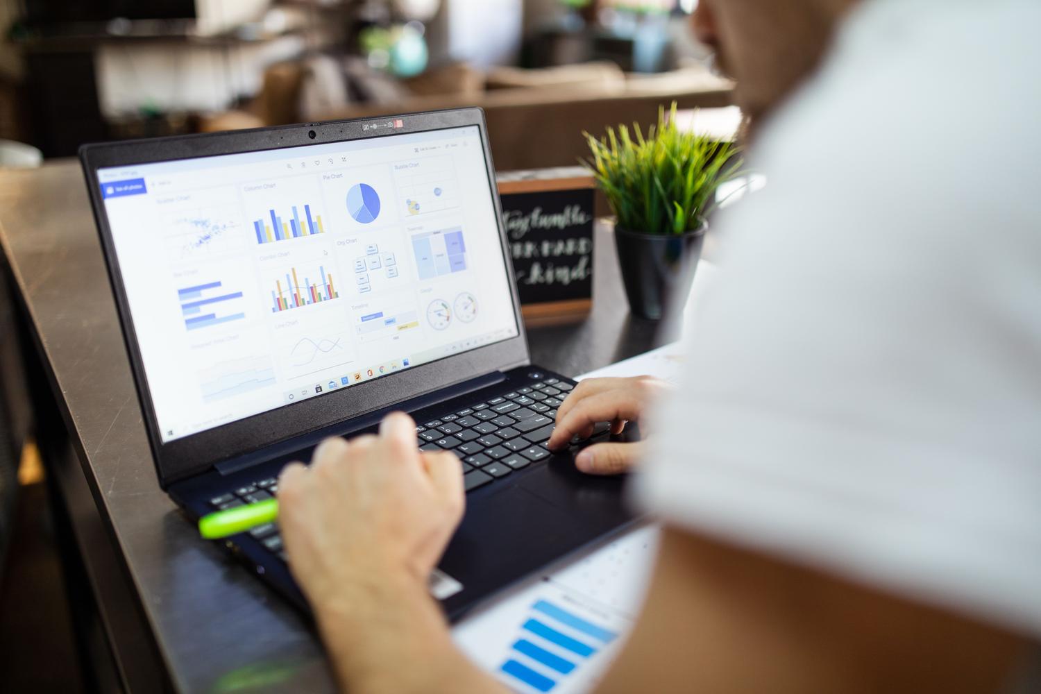 Analista revisando un panel de control de datos con diversos gráficos para optimizar campañas de marketing.