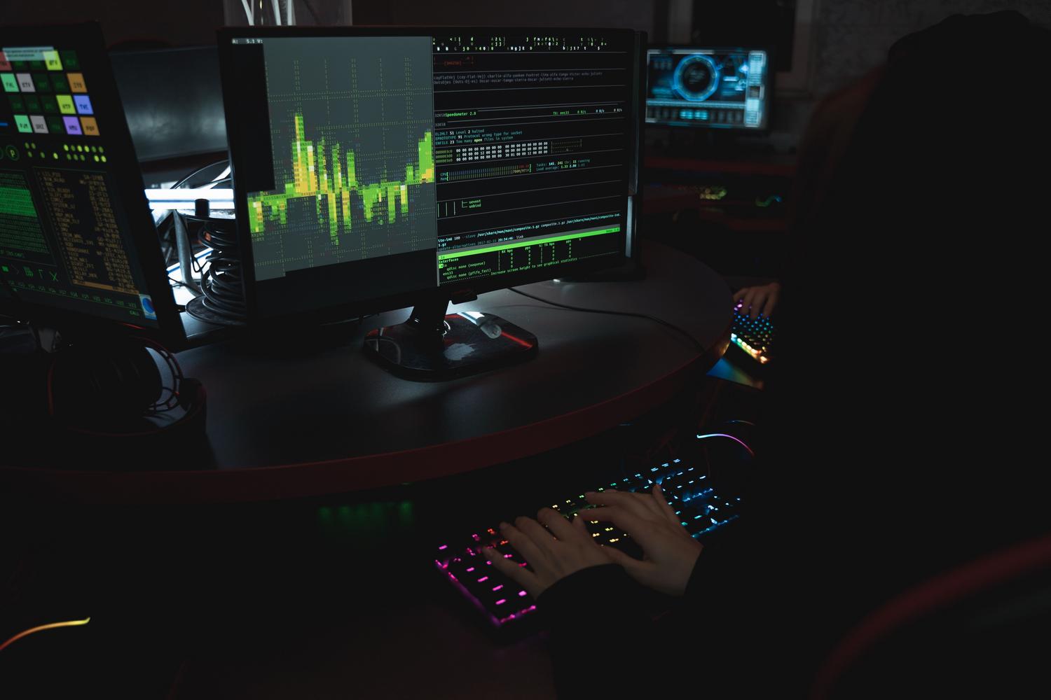 Especialista en seguridad trabajando en un entorno de centro de operaciones (SOC) con múltiples pantallas de código y datos, representando la gestión de vulnerabilidades.
