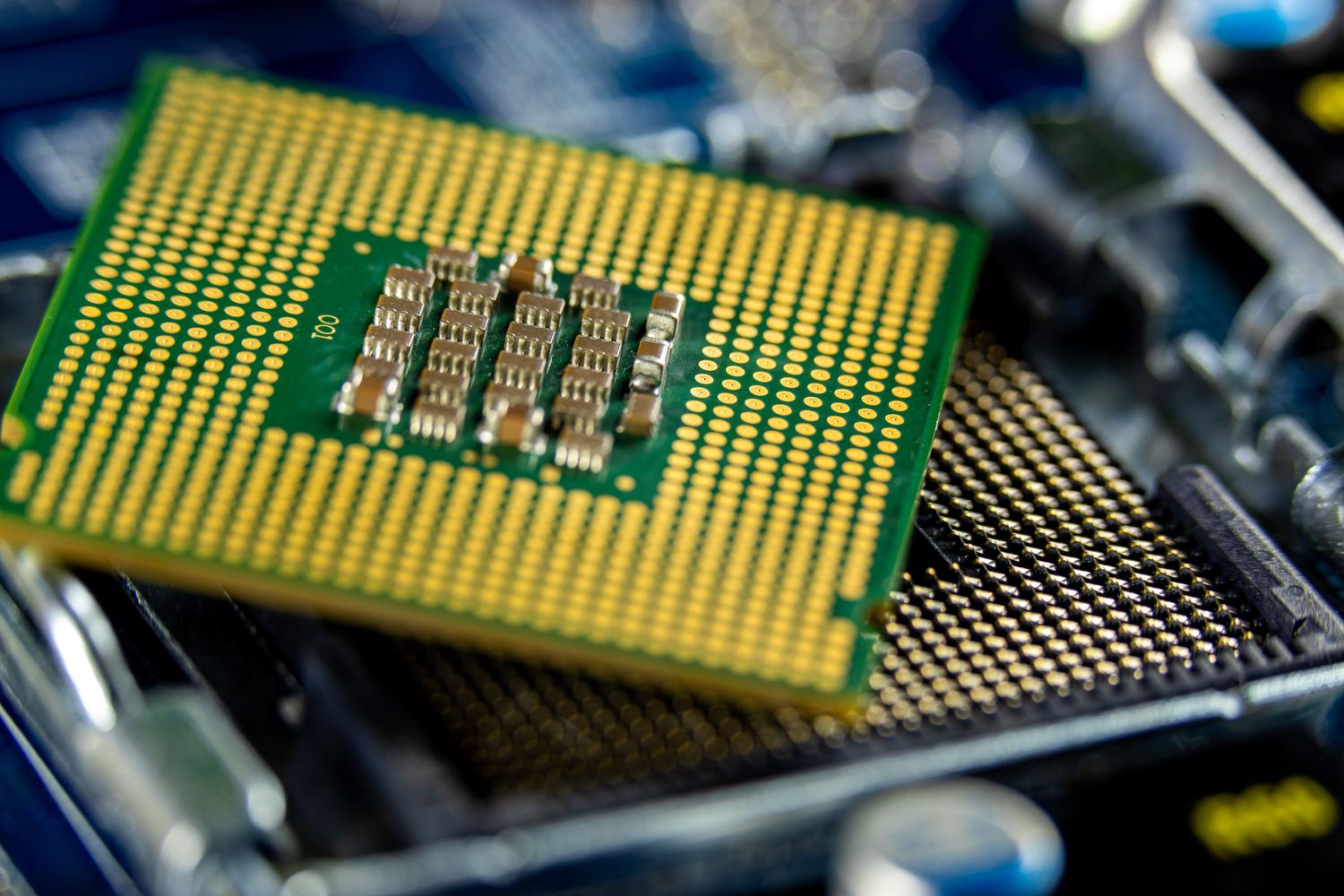 Detalle macro de un microprocesador en una placa base, ilustrando los diferentes tipos de chips para IA como TPUs y ASICs.