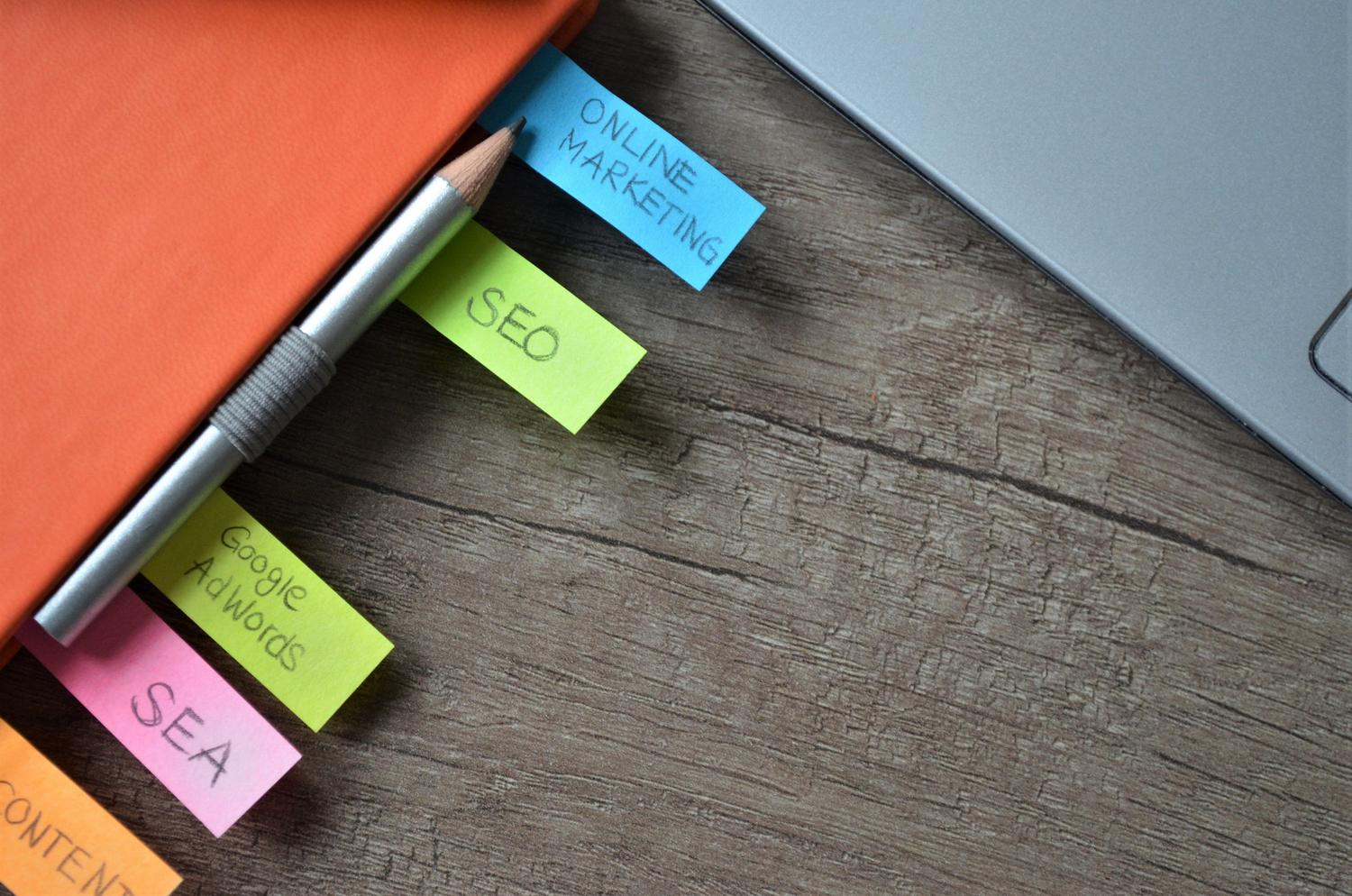 Planificador de estrategia SEO con notas adhesivas que mencionan SEO, SEA y Google AdWords.