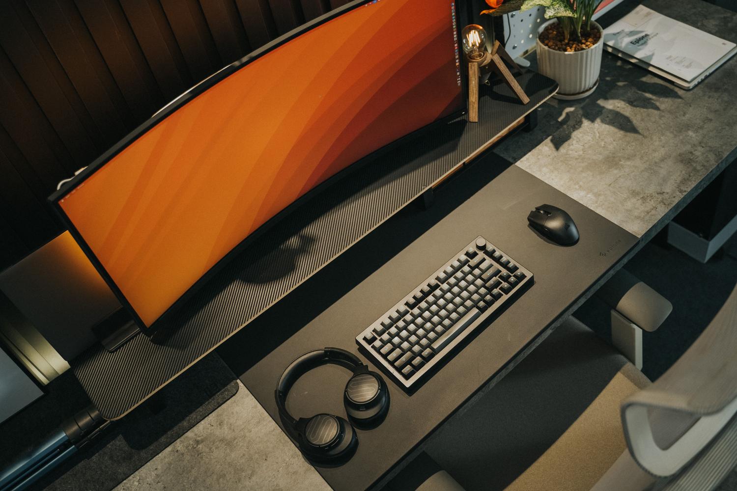 Escritorio gaming minimalista y moderno con un monitor curvo de alta resolución.