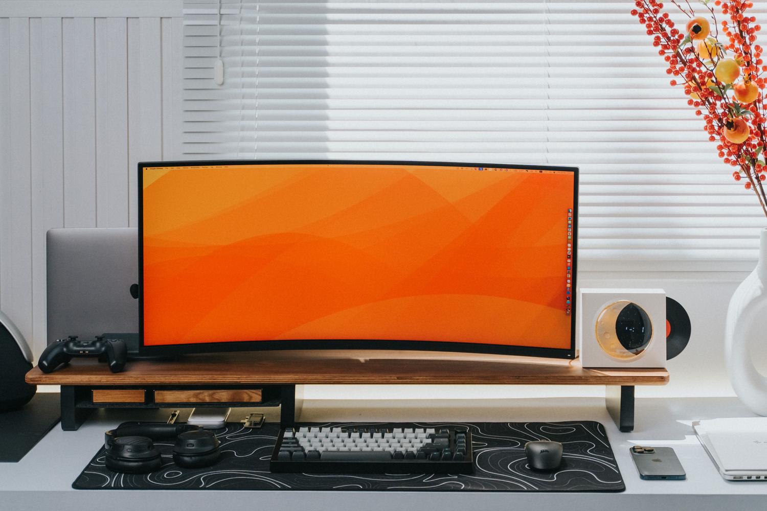 Espacio de trabajo moderno con monitor curvo ultrawide, ideal para la productividad y ergonomía.