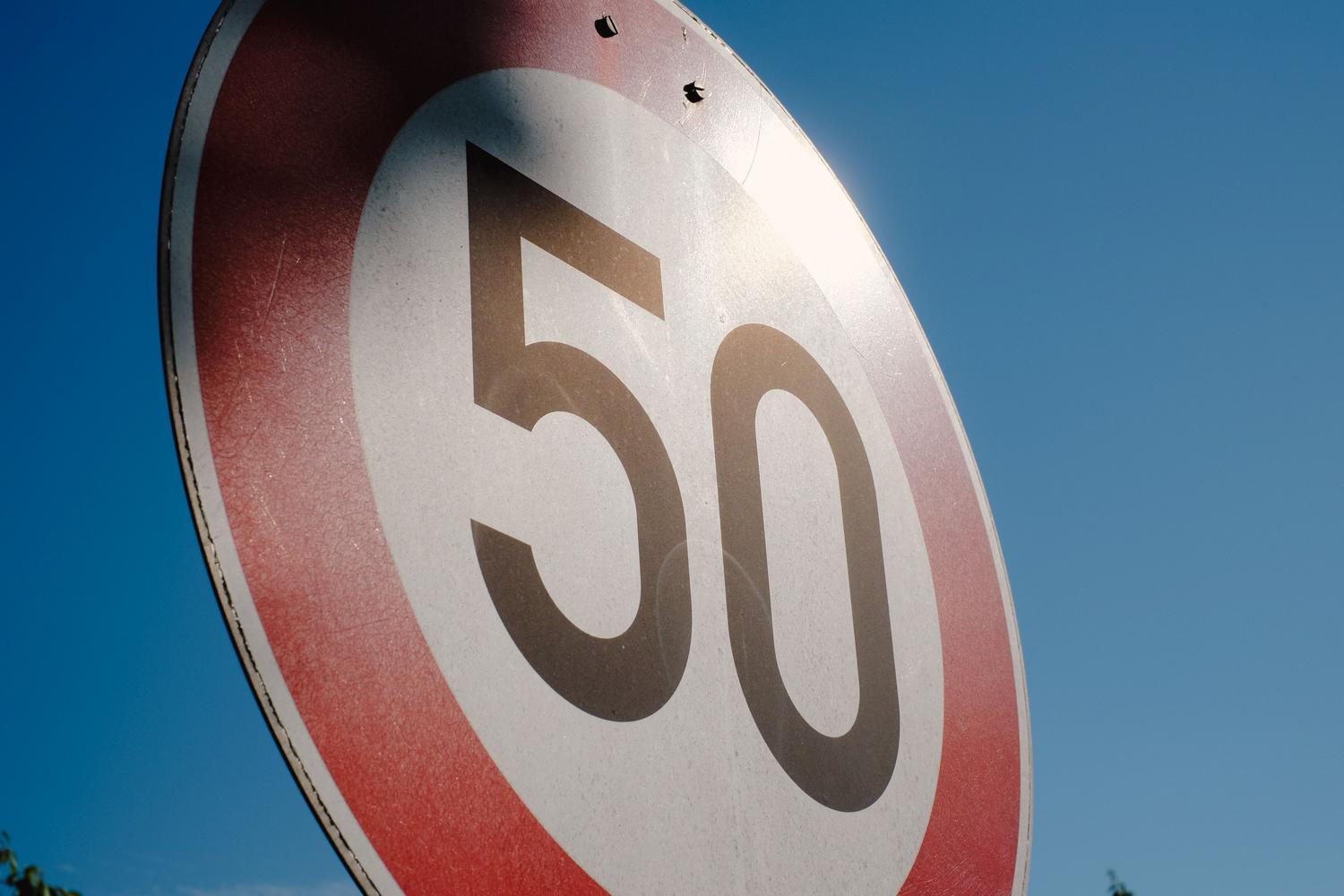 Señal de tráfico de límite de velocidad de 50 km/h sobre un fondo de cielo azul, ilustrando los límites permitidos.