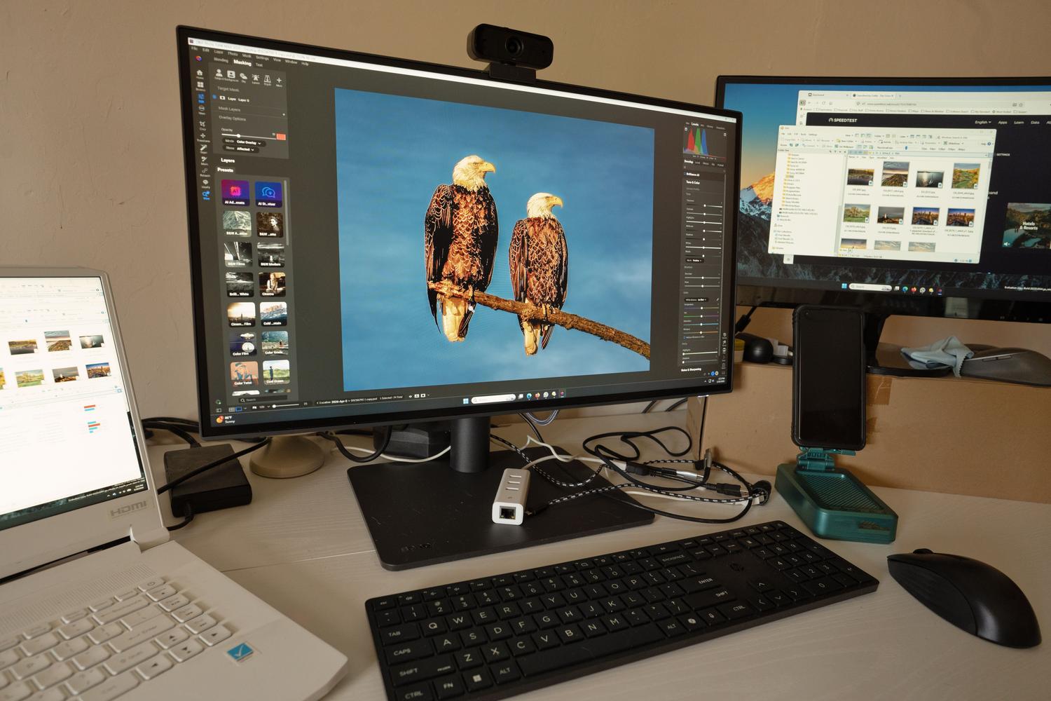 Estación de trabajo profesional con múltiples monitores realizando edición fotográfica, ilustrando la necesidad de resoluciones QHD y 4K.