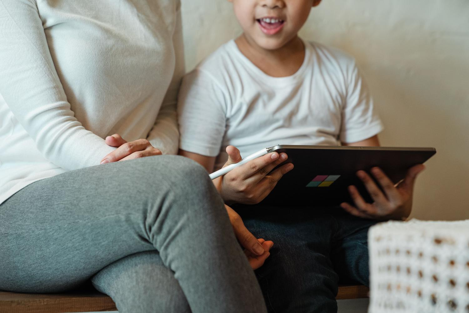 Madre e hijo interactuando juntos con una tablet en casa, ilustrando el concepto de acompañamiento consciente en el uso de la tecnología.