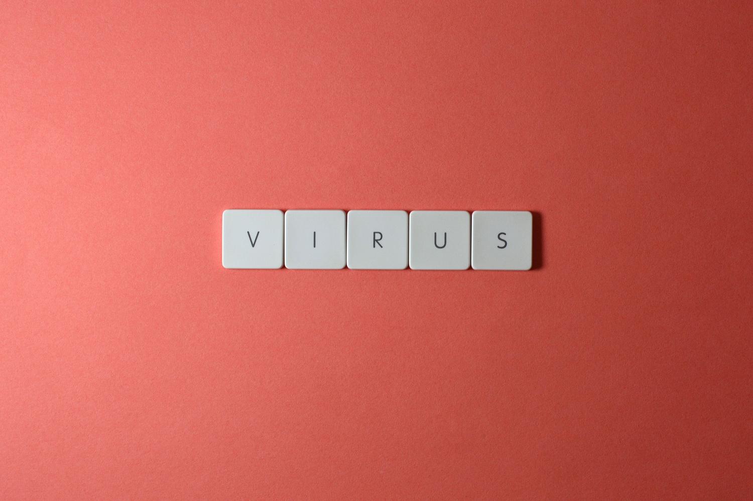 Teclas de un teclado formando la palabra 'virus', representando malware que ralentiza la red