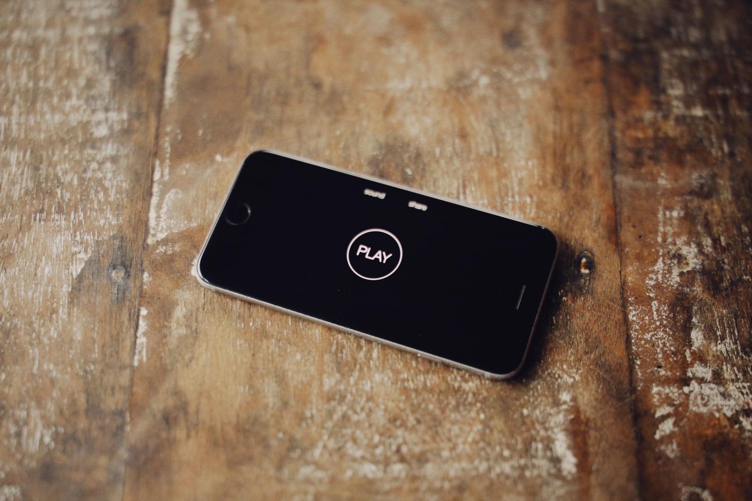 Smartphone apoyado sobre una mesa de madera con la pantalla apagada, representando un dispositivo congelado o apagado.
