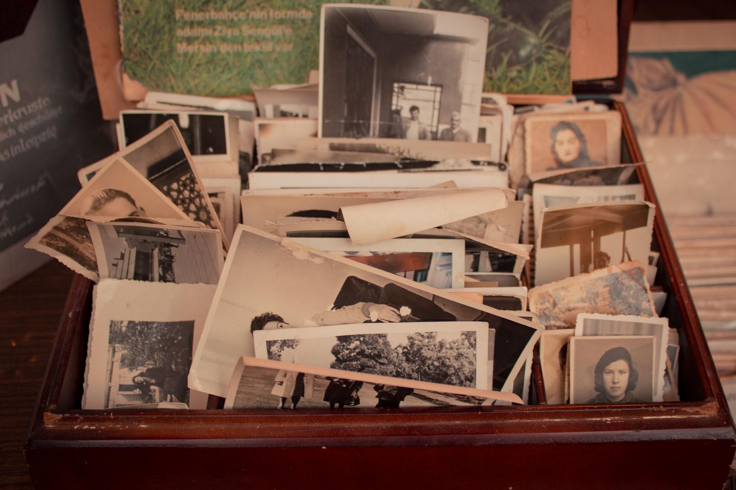 Colección de fotografías antiguas en blanco y negro guardadas en una caja de madera vintage.