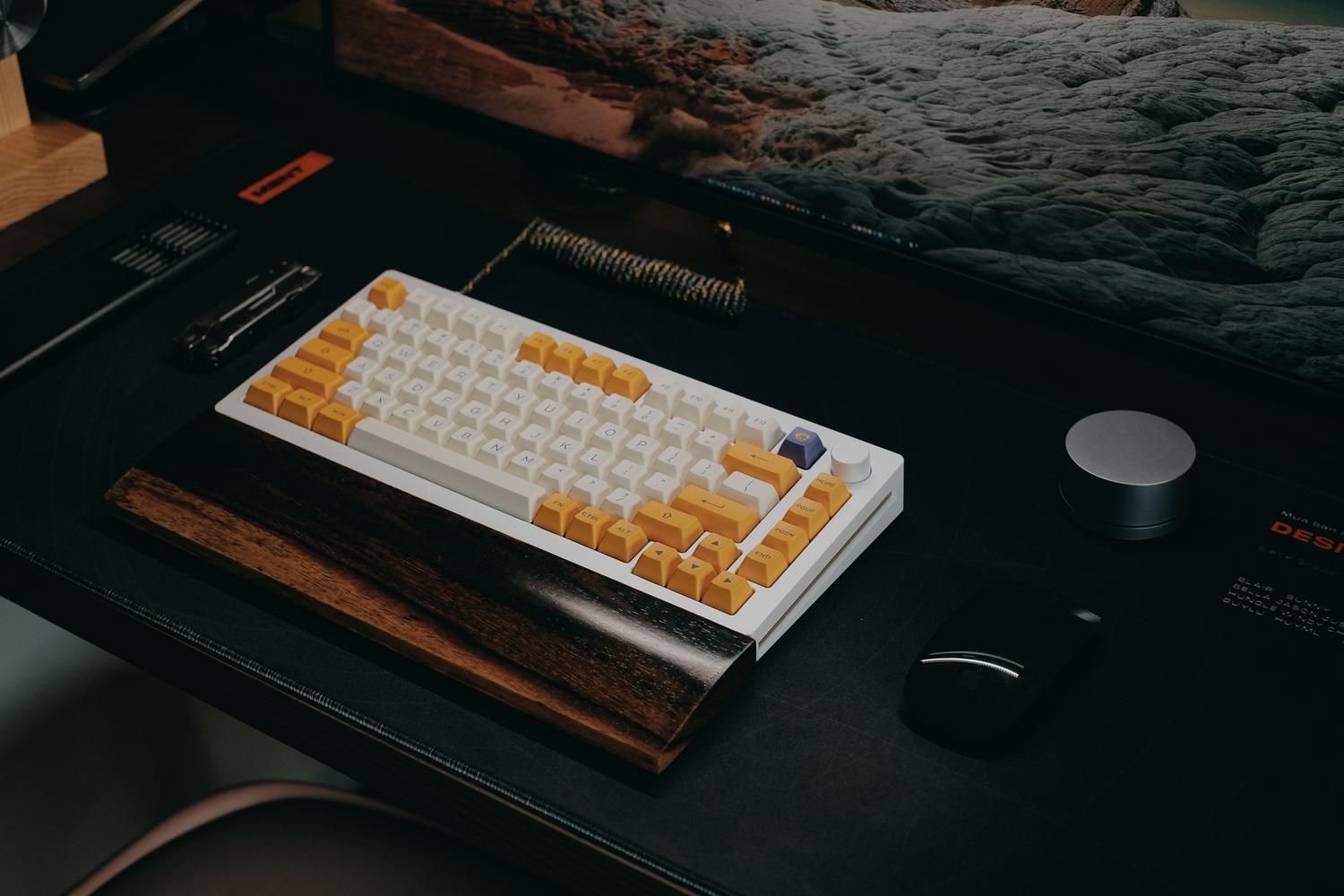 Configuración de teclado mecánico elegante en un escritorio de madera oscura para un entorno de oficina en casa.