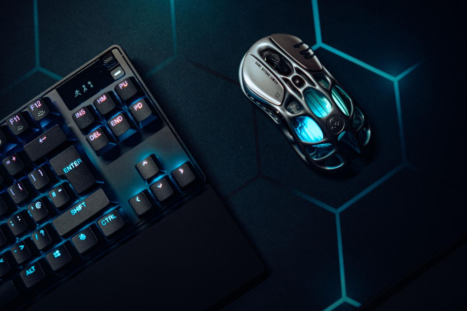 Teclado mecánico gaming con iluminación LED azul y ratón ergonómico en un entorno futurista.