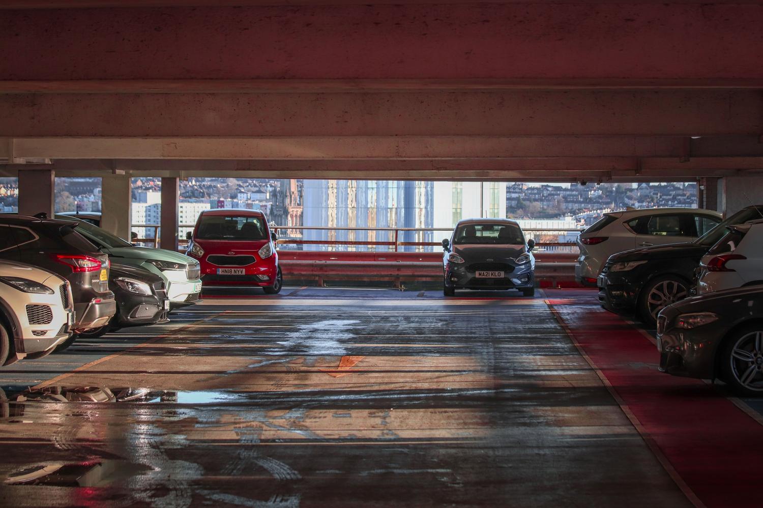 Vista general de un parking multinivel con múltiples vehículos, ilustrando la monotonía del entorno.