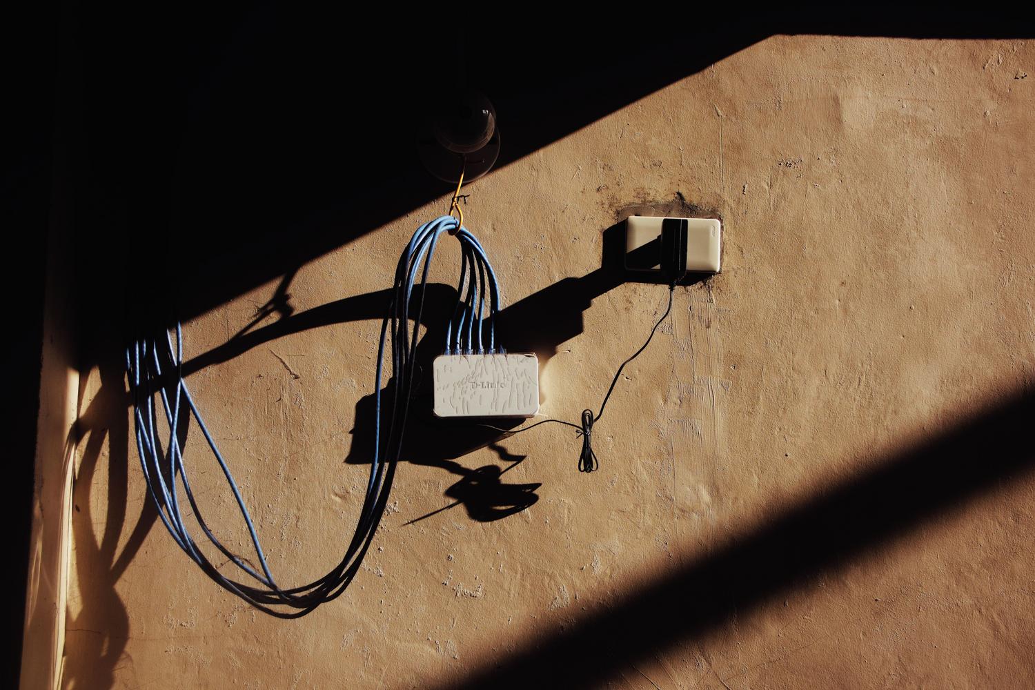 Instalación de un adaptador PLC conectado a la red eléctrica y un switch Ethernet para extender la señal de internet en el hogar.