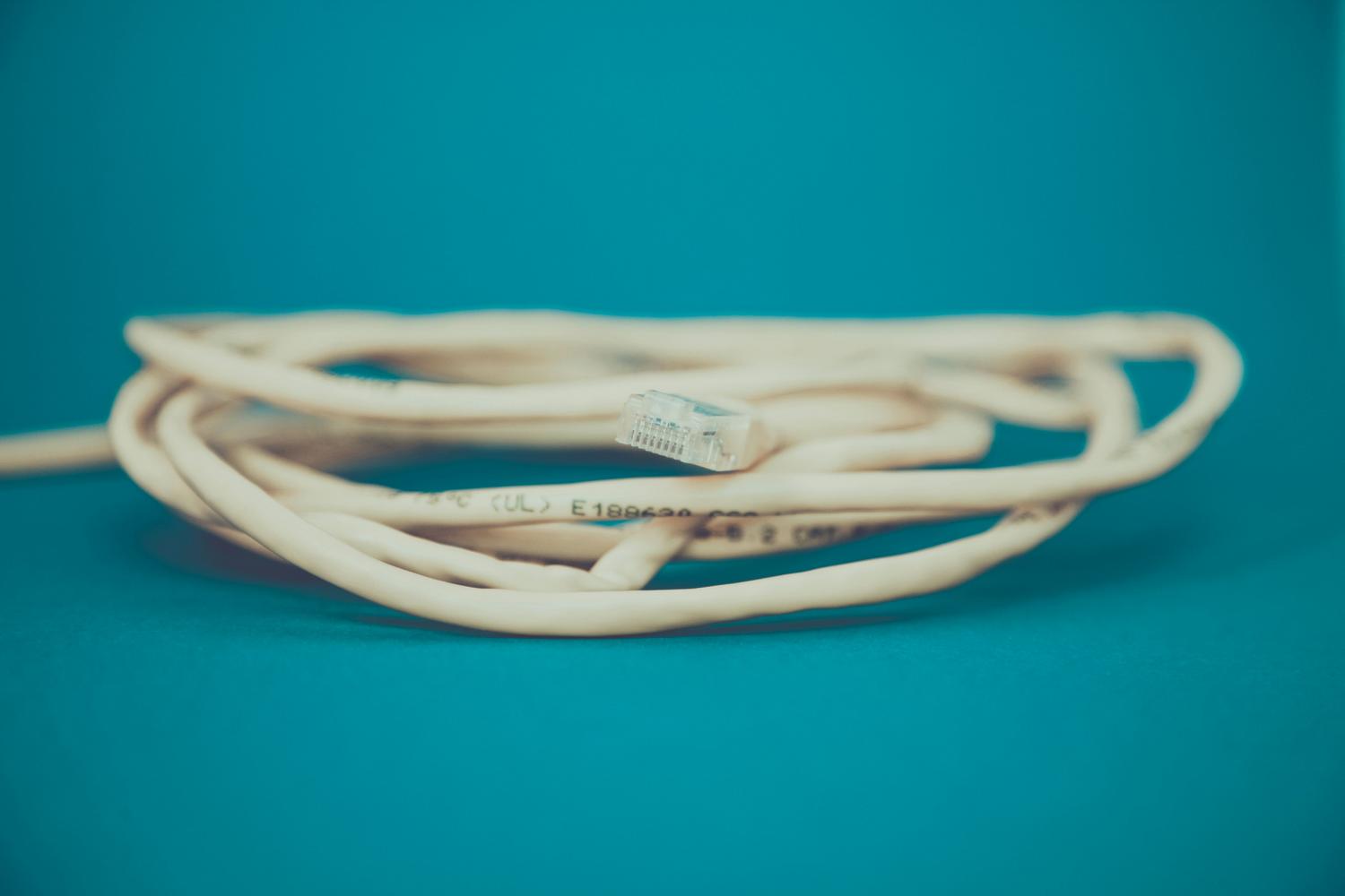 Primer plano de un cable Ethernet con conector RJ-45, simbolizando la estabilidad y velocidad de una conexión cableada.