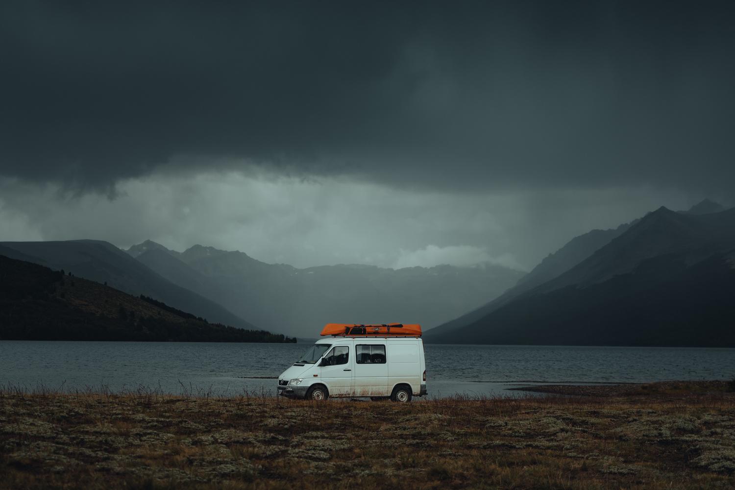 Furgoneta camper estacionada junto a un lago de montaña, capturando la esencia de la libertad y el contacto estrecho con la naturaleza. Furgoneta camper estacionada junto a un lago de montaña, capturando la esencia de la libertad y el contacto estrecho con la naturaleza.