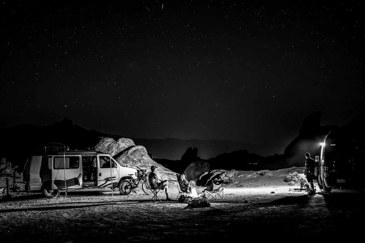 Acampada nocturna con una furgoneta camper y una fogata bajo un cielo estrellado, mostrando el lado más aventurero y la experiencia de pernoctar en exteriores. Acampada nocturna con una furgoneta camper y una fogata bajo un cielo estrellado, mostrando el lado más aventurero y la experiencia de pernoctar en exteriores.