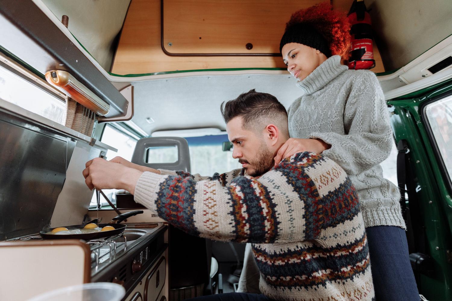 Pareja cocinando el desayuno en el interior de su camper, representando la realidad económica y la gestión de las comidas caseras en el nomadismo. Pareja cocinando el desayuno en el interior de su camper, representando la realidad económica y la gestión de las comidas caseras en el nomadismo.