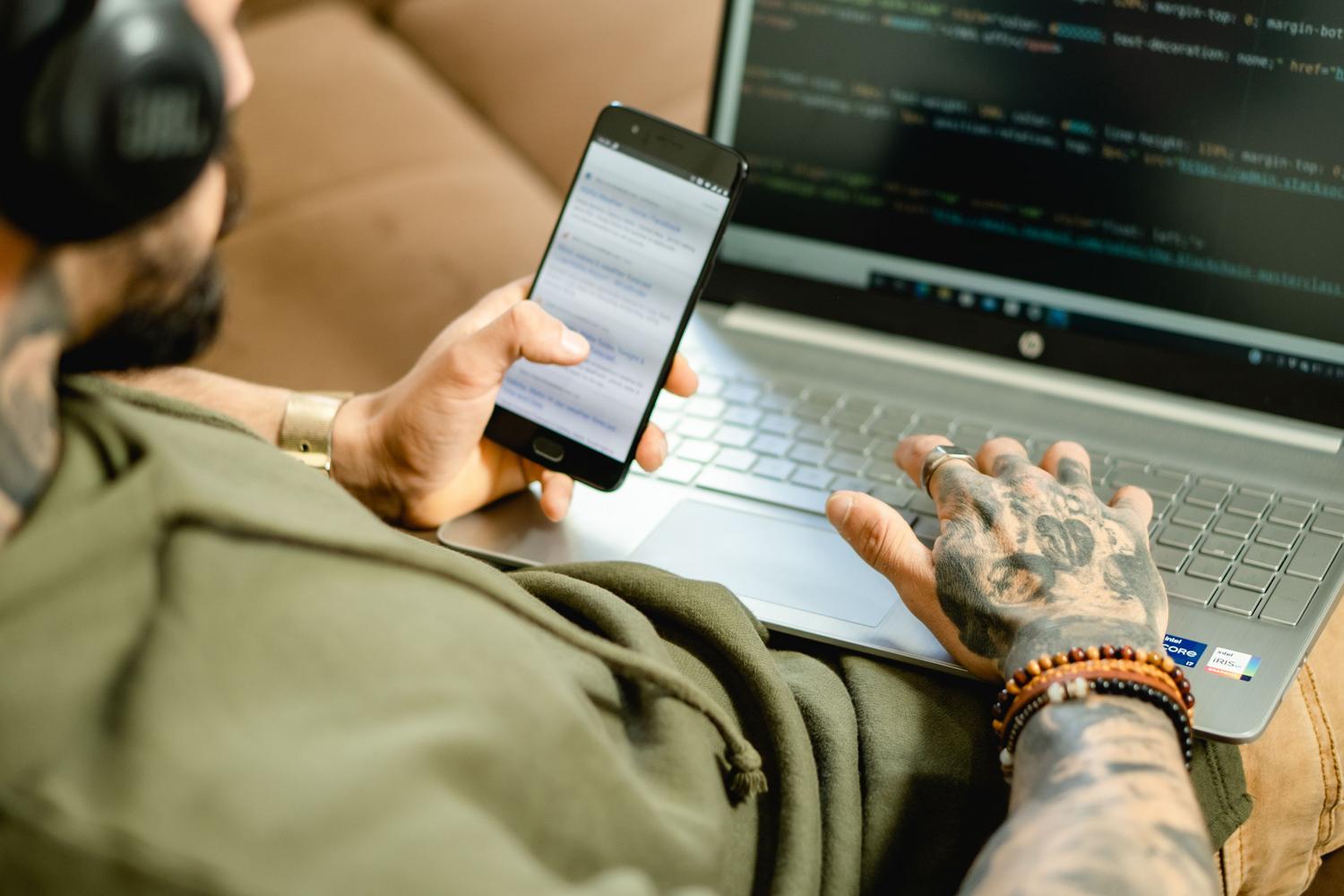 Desarrollador implementando librerías de seguridad en una aplicación Android utilizando un ordenador y un smartphone.