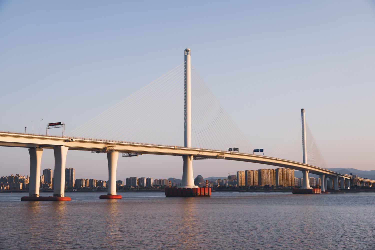 Impresionante puente atirantado moderno sobre el agua, ejemplo de ingeniería avanzada y uso de materiales de alta gama.