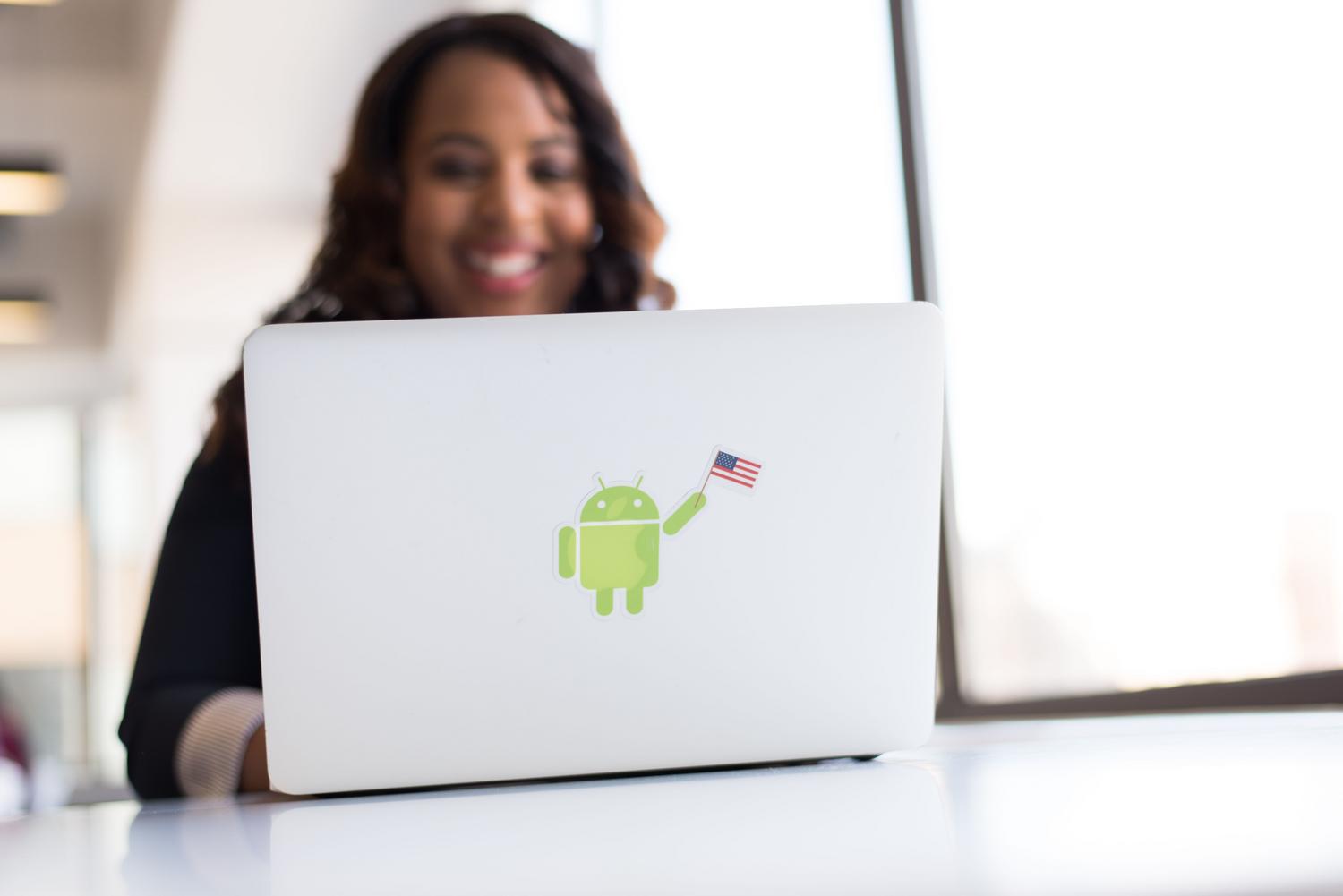 Espacio de trabajo profesional con un portátil que muestra una pegatina del robot de Android, ideal para desarrolladores Android.