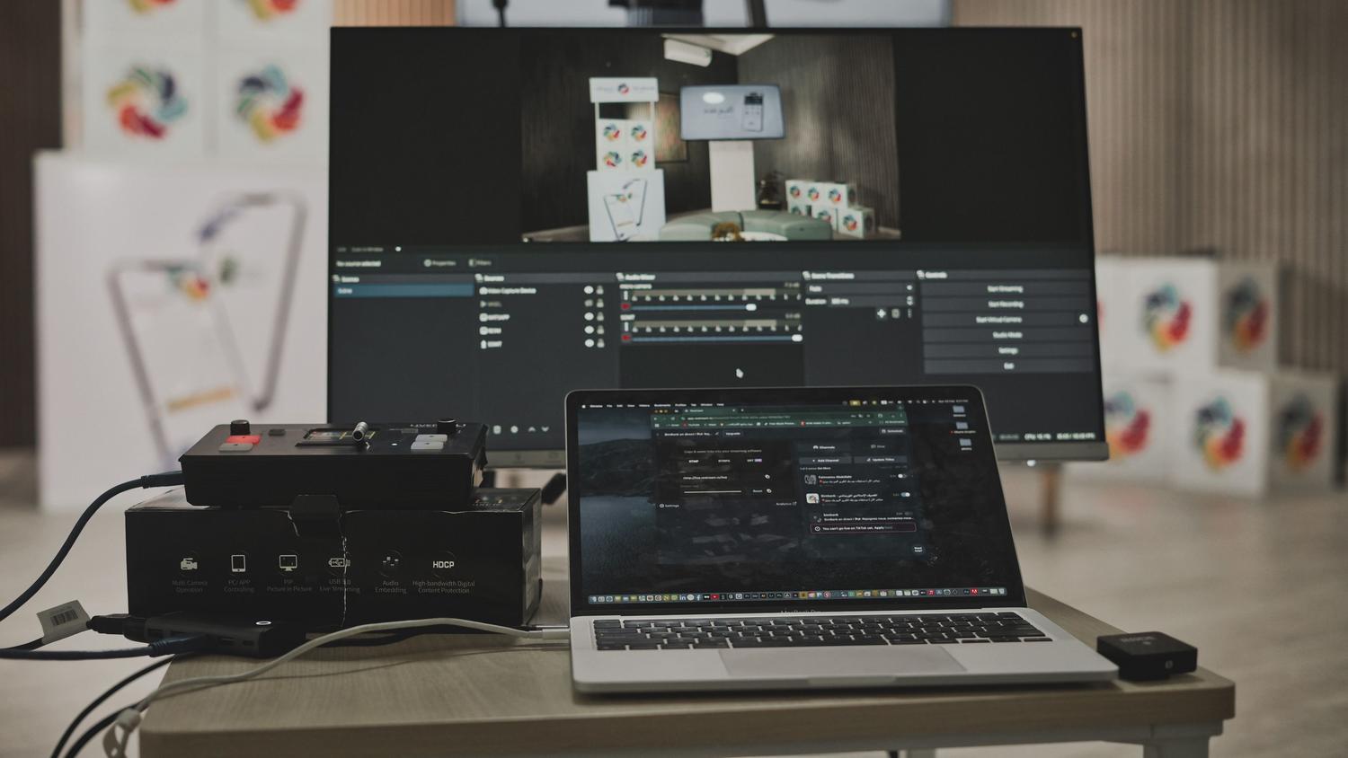 Configuración multimedia con portátil y monitor grande en un espacio de trabajo tecnológico, reflejando la productividad potenciada por la IA.