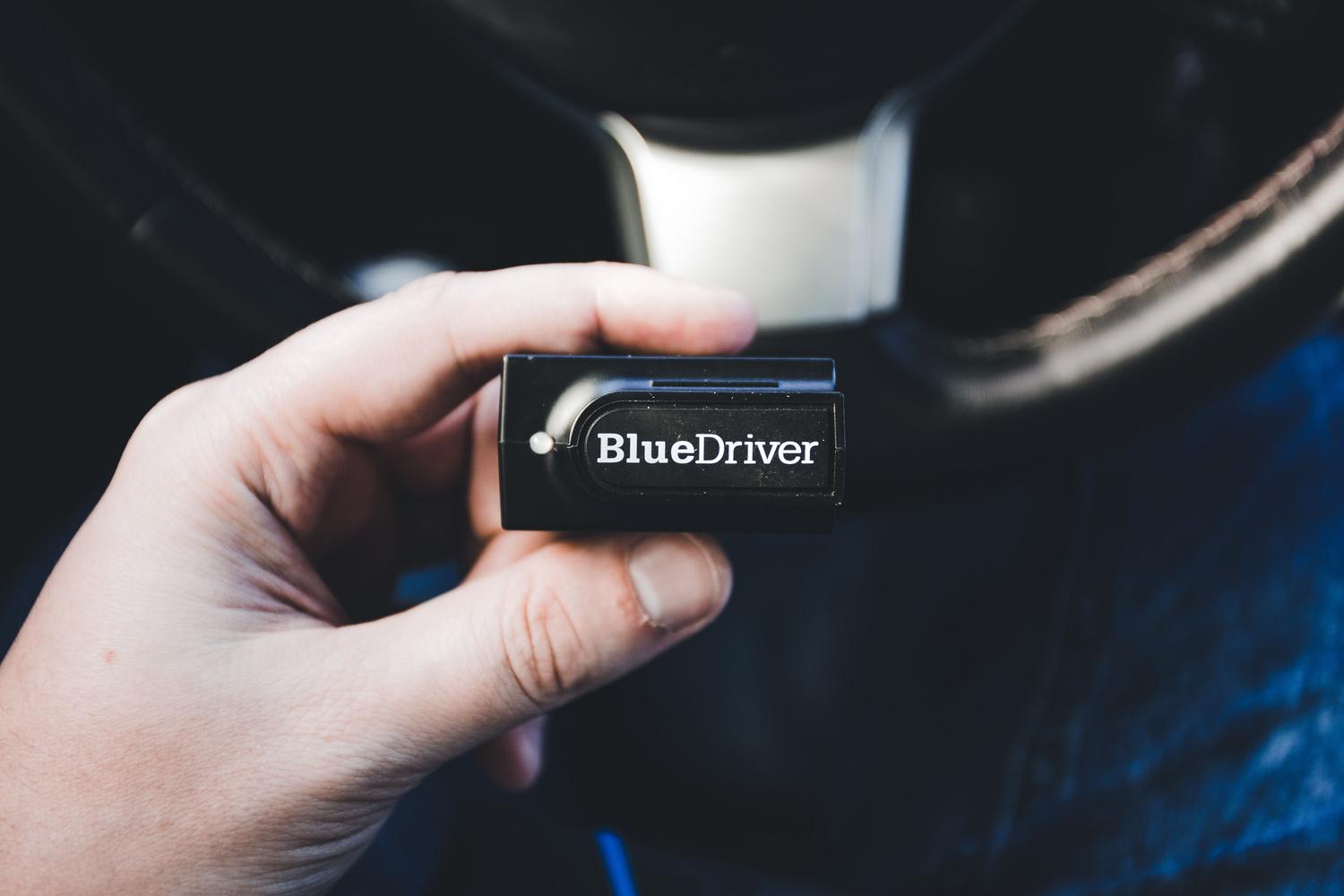 Primer plano de un escáner de diagnosis electrónico BlueDriver utilizado para leer códigos de error en la computadora del coche.