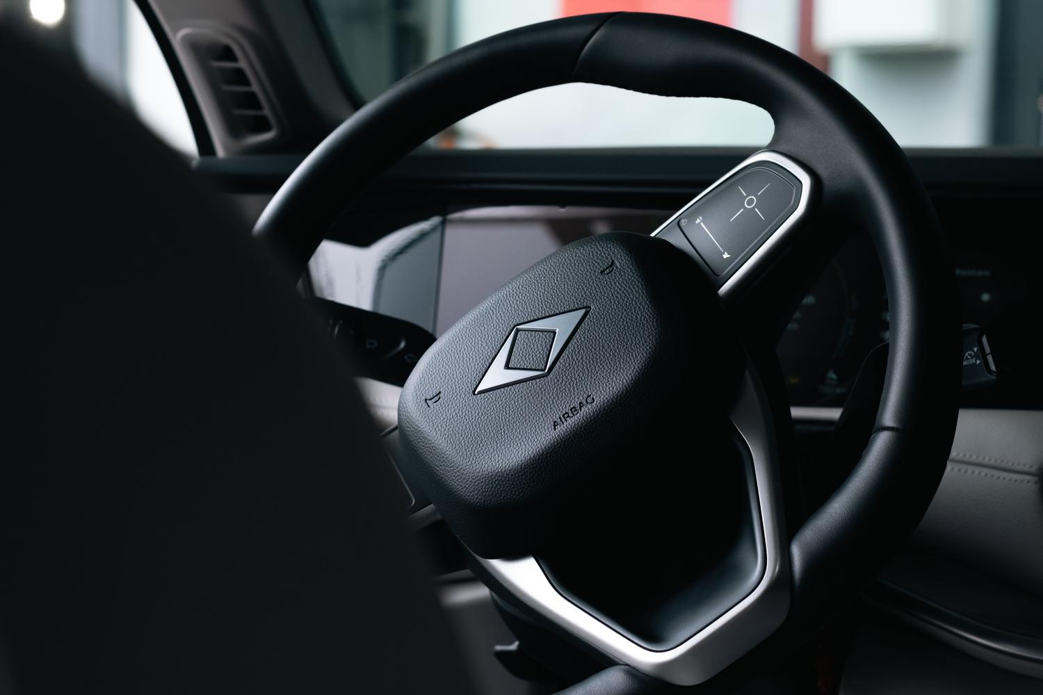 Primer plano de un volante de coche moderno con mandos multifunción y cuadro digital, representando la comodidad de la dirección asistida eléctrica.