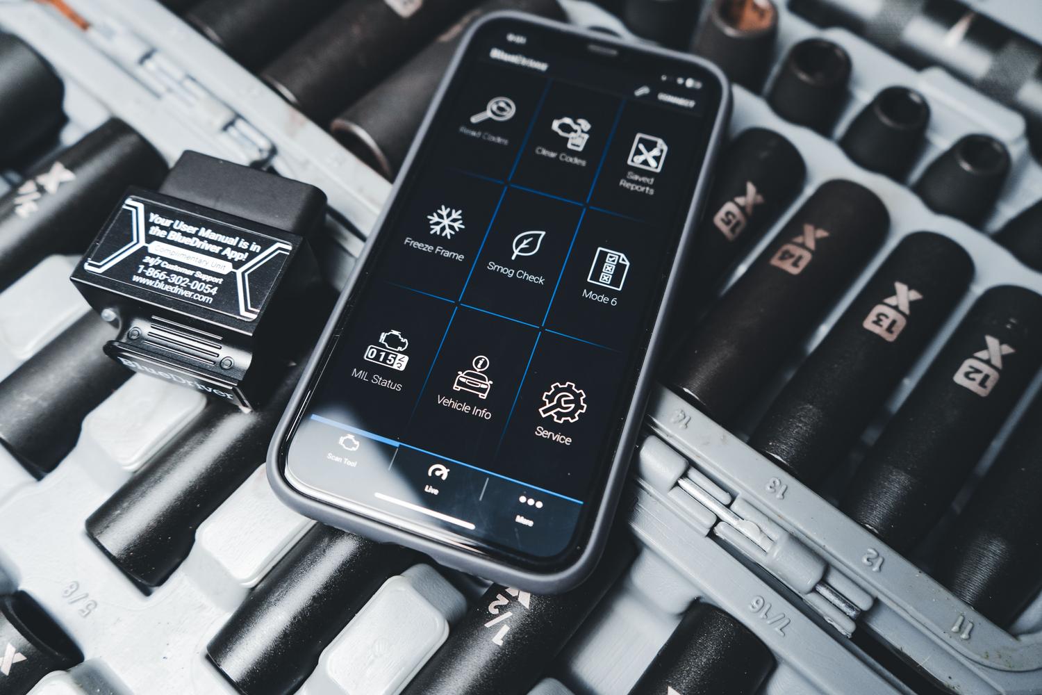 Smartphone mostrando una aplicación de diagnóstico automotriz conectada a un escáner OBD2 para detectar códigos de error.