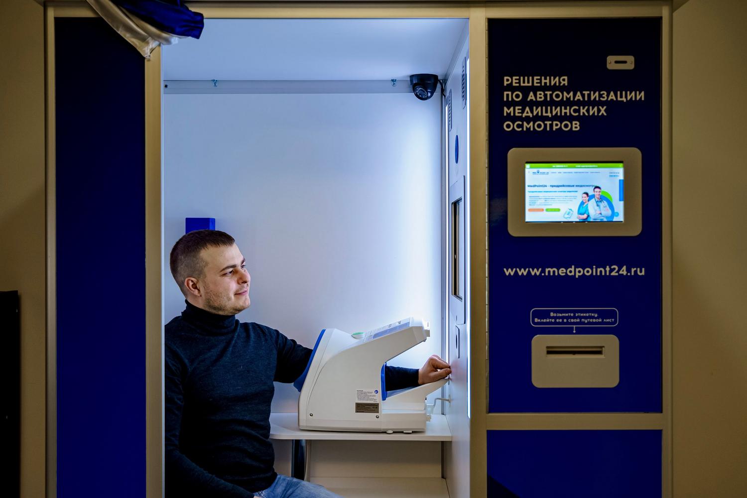 Hombre utilizando un quiosco de salud automatizado para realizarse chequeos médicos preventivos.