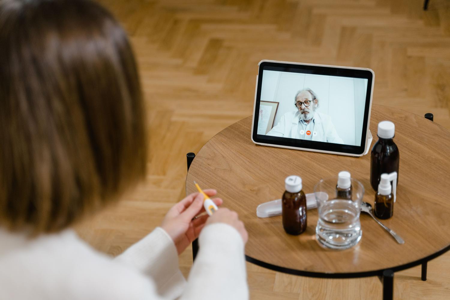 Consulta de telemedicina entre un médico y una paciente a través de una tablet en el hogar.