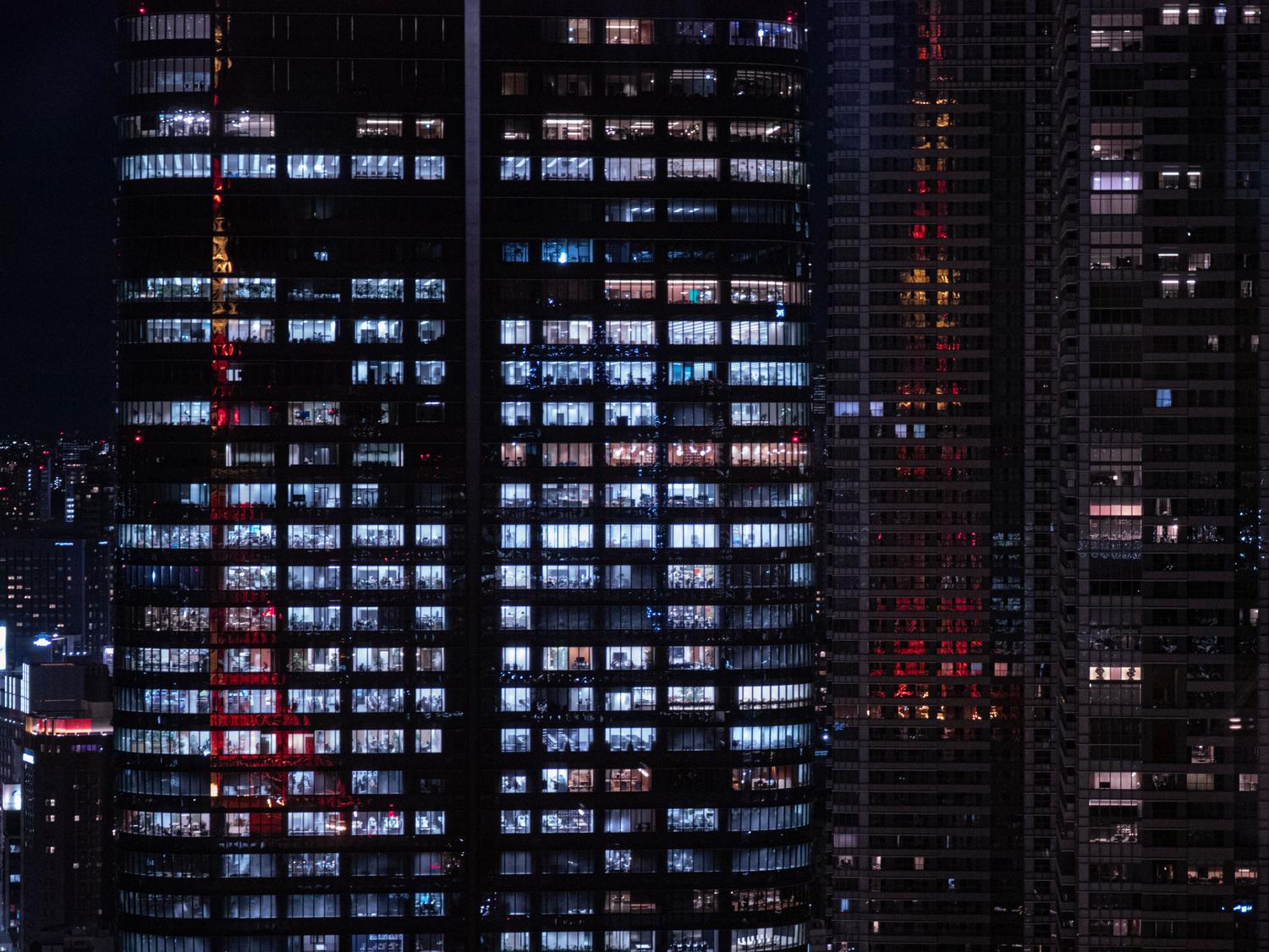 Rascacielos modernos y colosales iluminados de noche, representando el poder opresivo de las megacorporaciones en una ciudad futurista. Rascacielos modernos y colosales iluminados de noche, representando el poder opresivo de las megacorporaciones en una ciudad futurista.