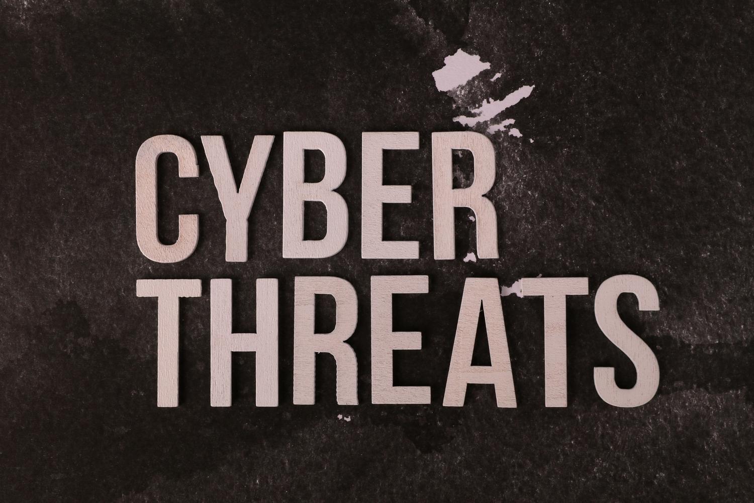 Letras sobre fondo oscuro que forman la frase Cyber Threats, representando las vulnerabilidades y riesgos digitales.