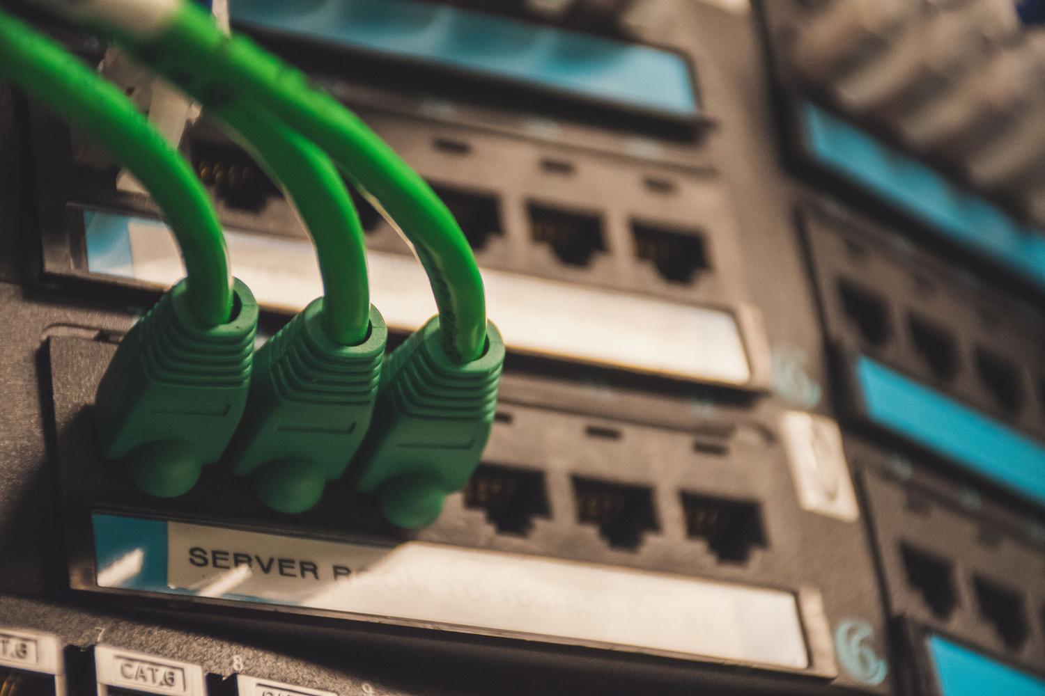 Detalle de cables de red conectados a un servidor, simbolizando la arquitectura de sincronización y conectividad de Syncthing.