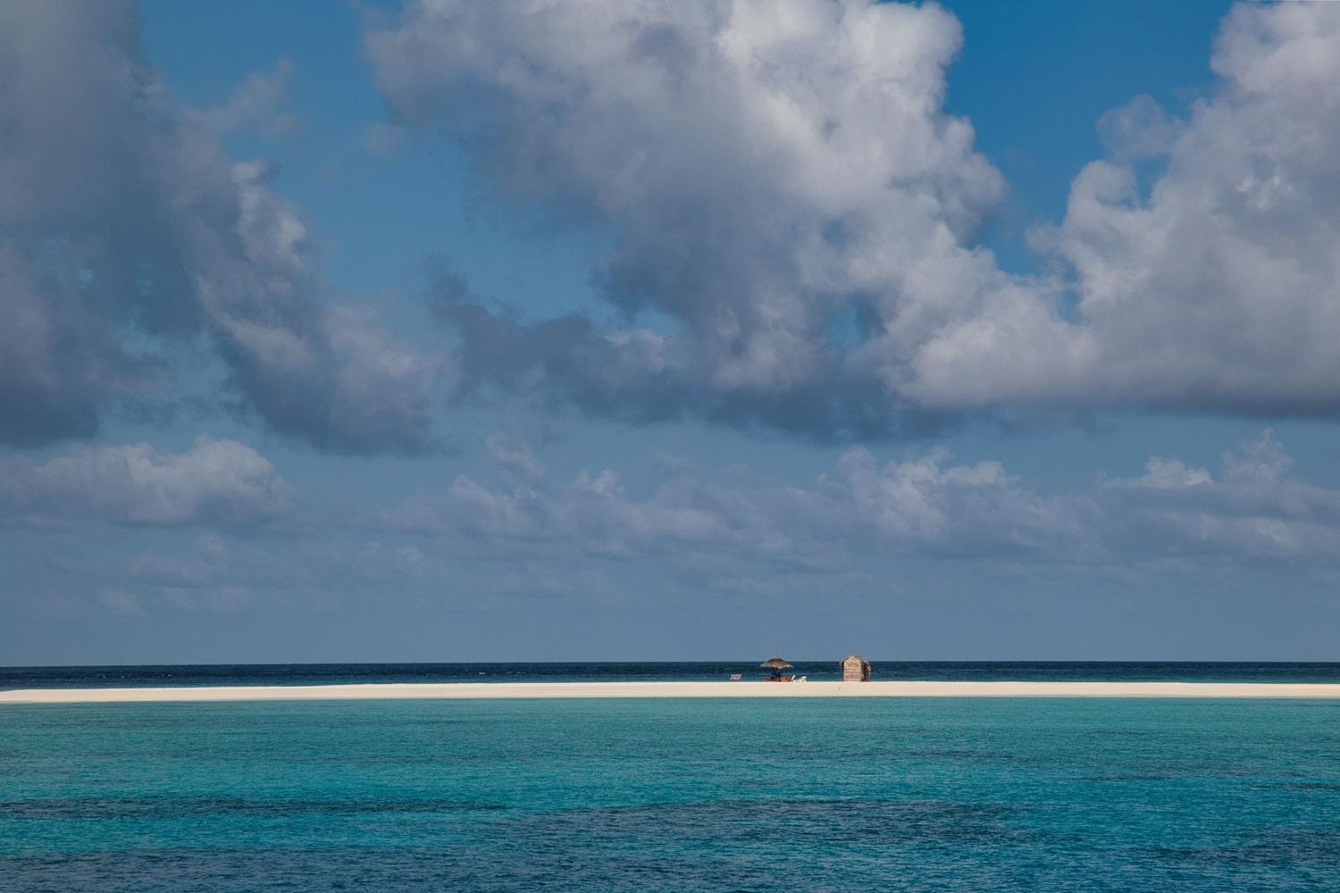 Playa tropical solitaria y serena que evoca la sensación de aislamiento y supervivencia.